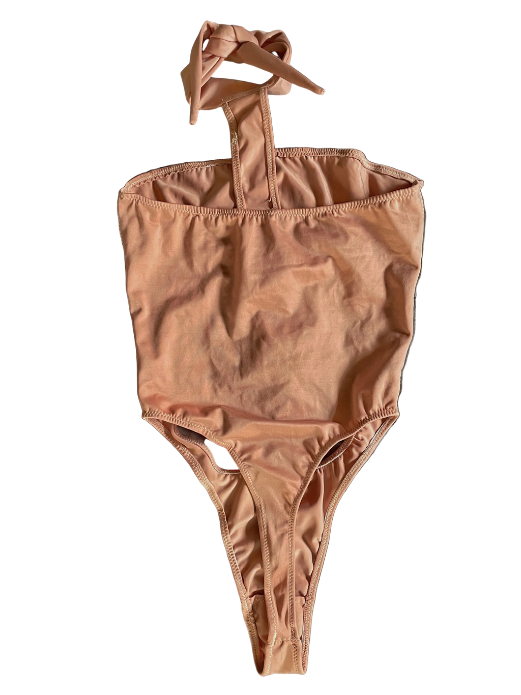 Back of apricot pink monokini with a halter neck design and thong coverage on a white background