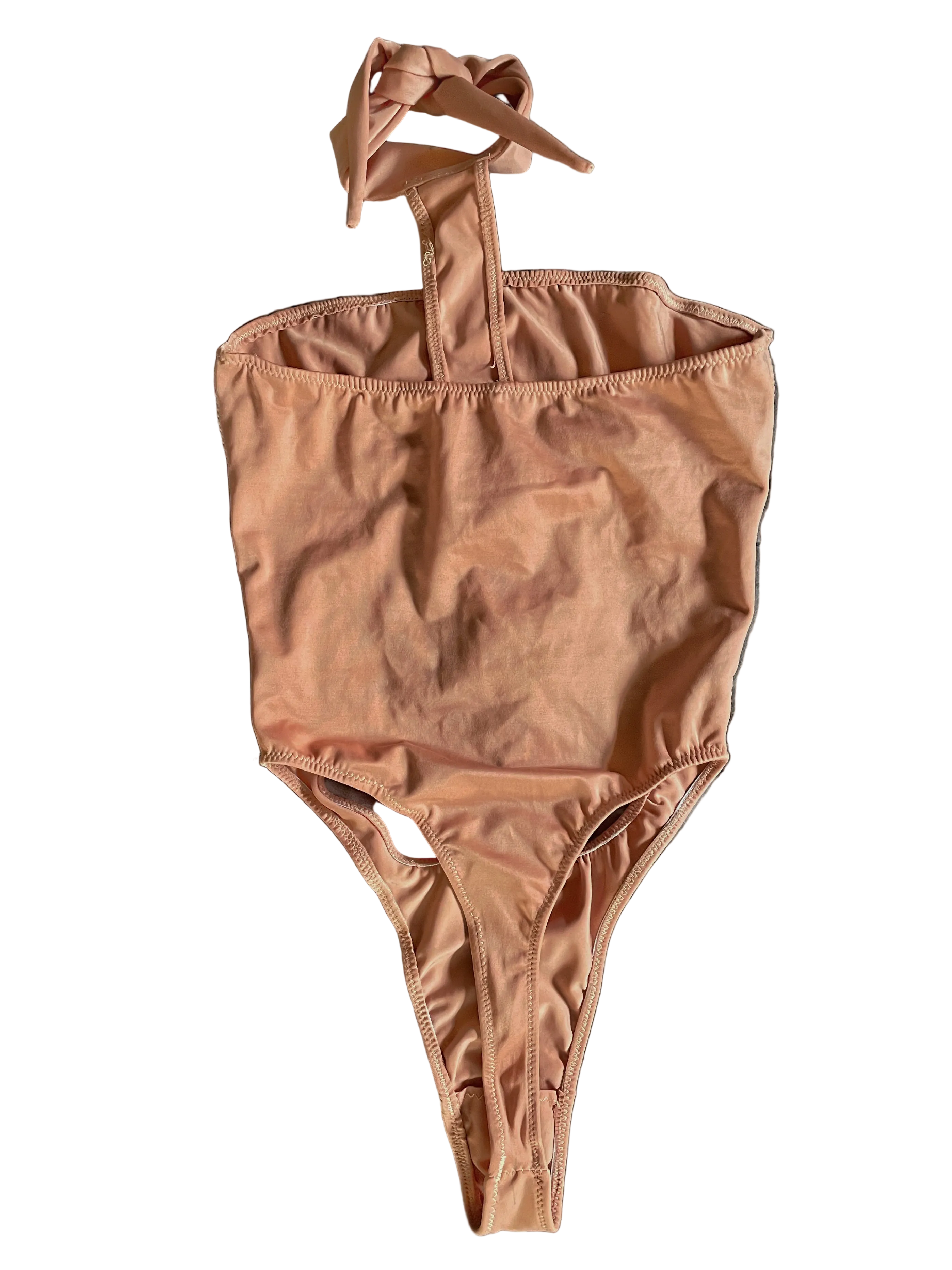 Back of apricot pink monokini with a halter neck design and thong coverage on a white background