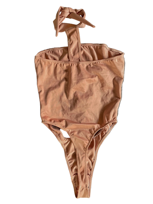 Back of apricot pink monokini with a halter neck design and thong coverage on a white background
